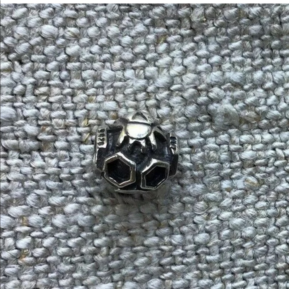 Searching for trollbead bee on a hive charm